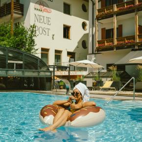 frau liegt auf matratze im pool
